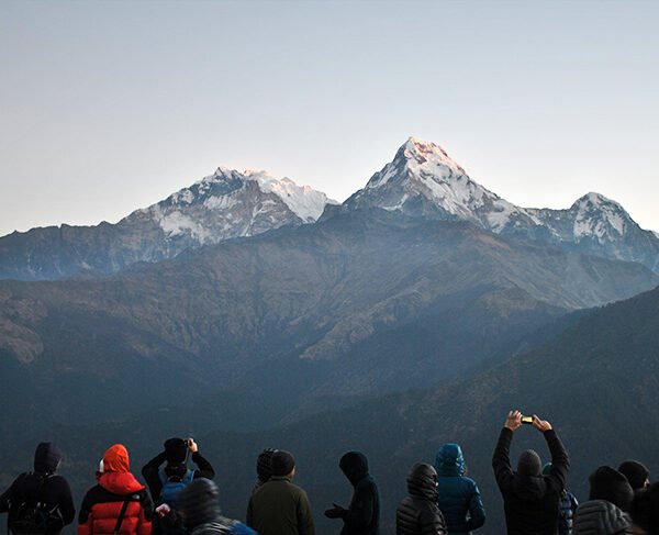 Elevate Trek-Tourists at Poon Hill summit, admiring the Annapurna and Dhaulagiri mountain ranges.
