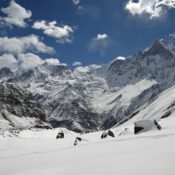 Elevate Trek- A snowy mountain range with blue sky and clouds