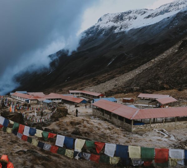 Elevate Trek- Trekking route to Annapurna Base Camp in Ghandruk, Nepal, adorned with small tin roof houses and prayer flags