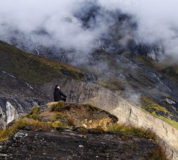 Elevate Trek- Man in black jacket sitting amidst mountain fog in Ghandruk