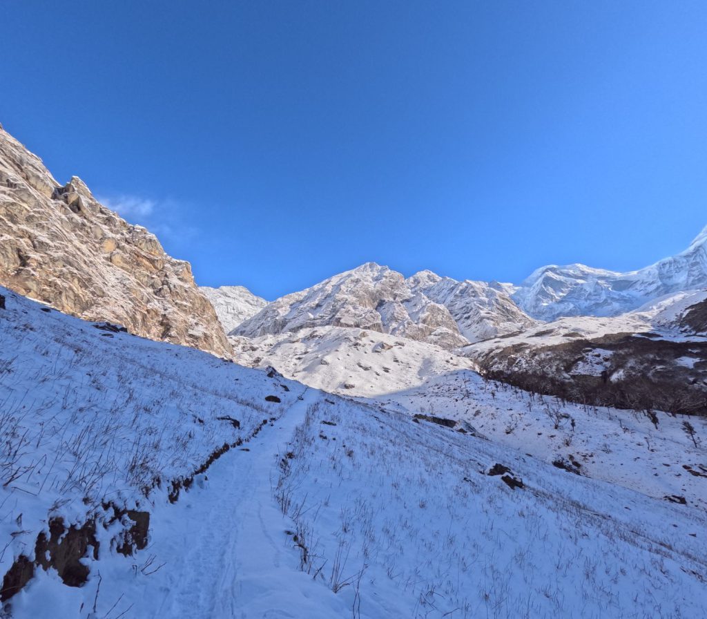 Scenic view of a snow-covered path leading to majestic mountains in Byash, Nepal.