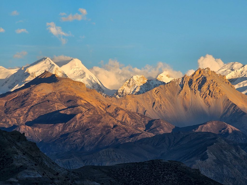Stunning view of Nepal Himalayas at sunset with golden light illuminating the peaks.