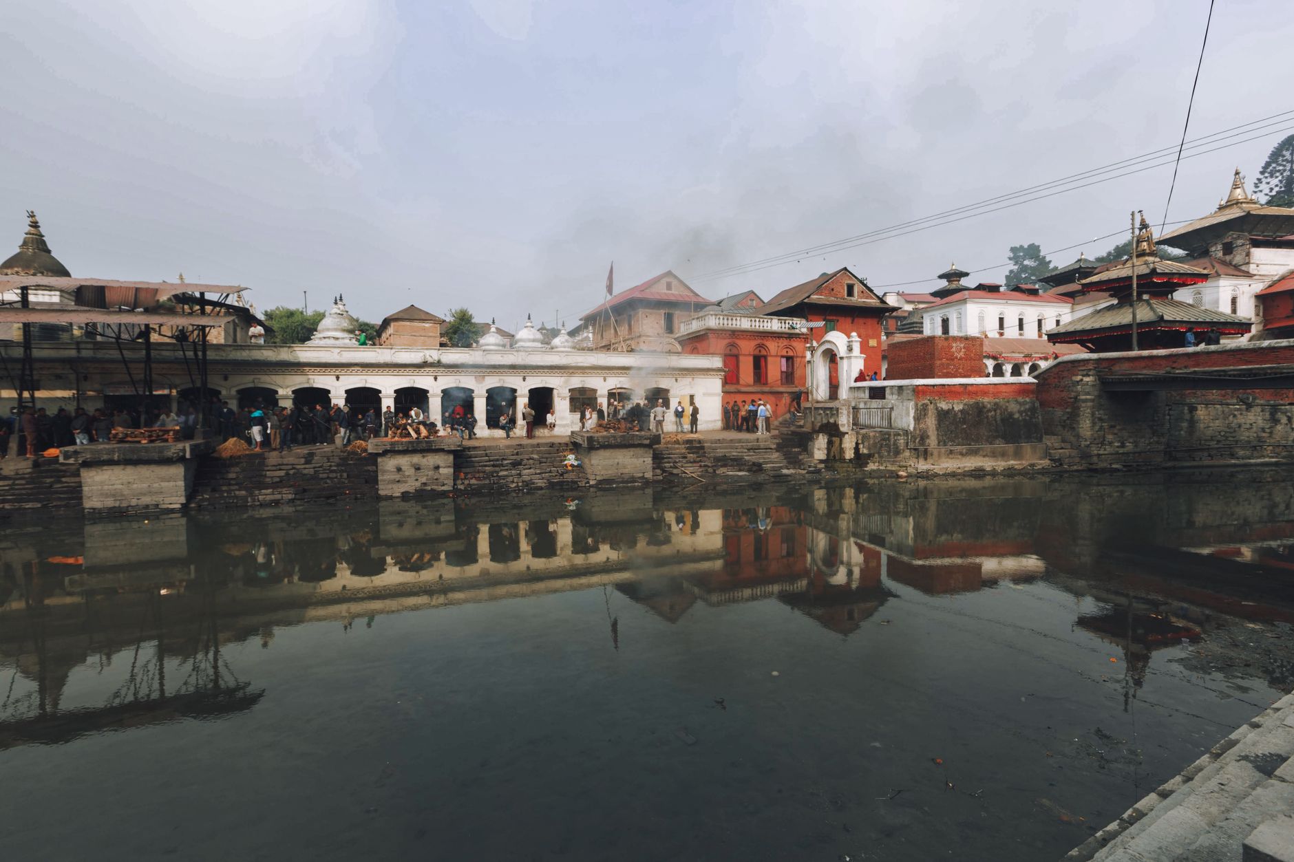 A scenic view of the Pashupatinath Temple with reflections in the Bagmati River.