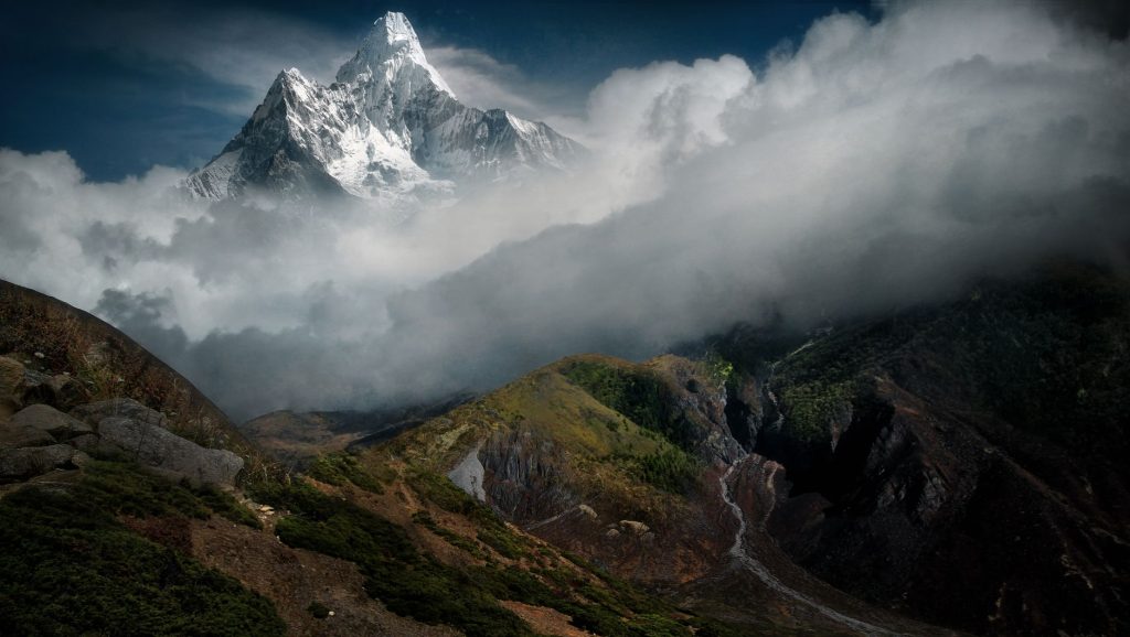 Spectacular view of Mount Ama Dablam, Nepal, shrouded in clouds with a rugged foreground.